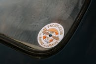 Close-up of a vintage car sticker on a moist windshield, capturing a classic automotive vibe.