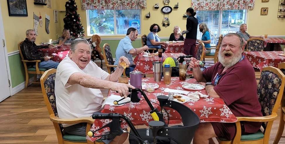 peope in the assisted living florida, enjoying the fodd and laughing with each other